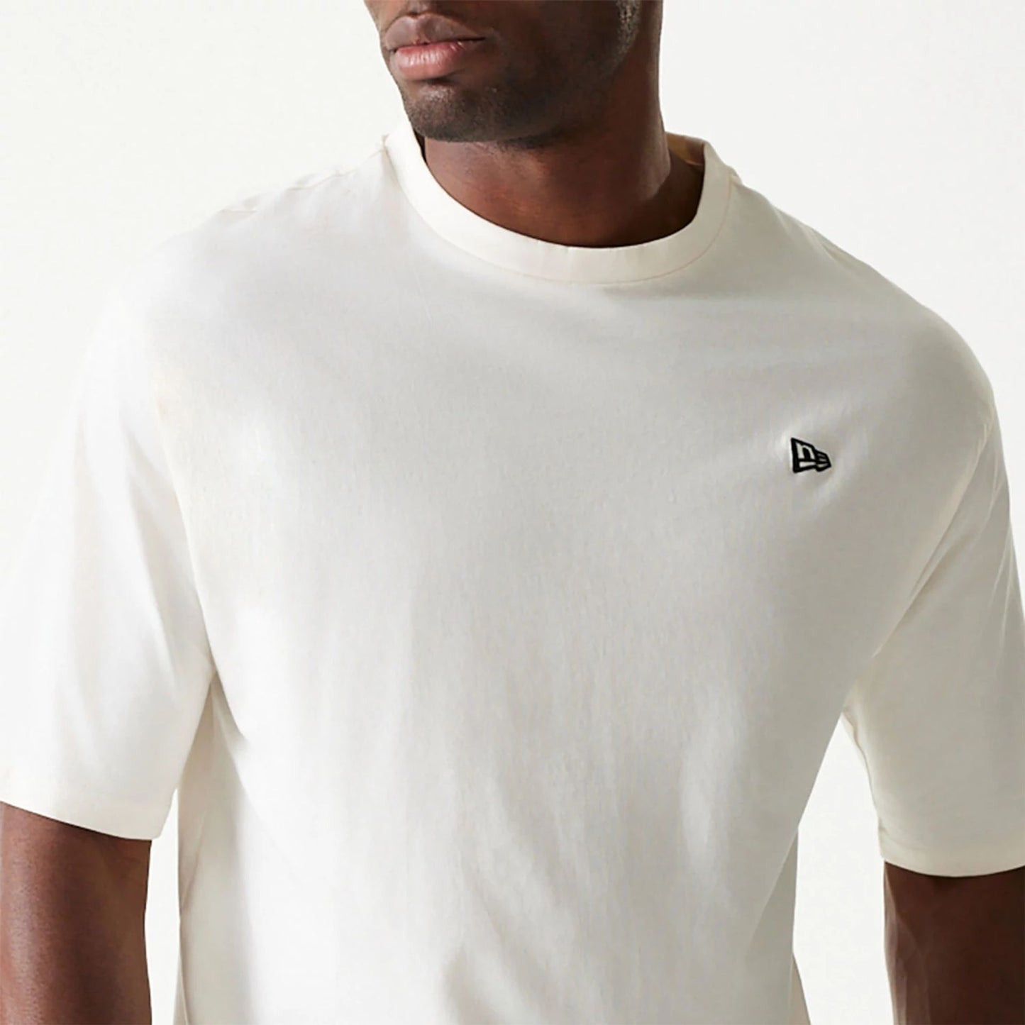 The Male model is wearing New Era Essential Cream Oversized T-Shirt 3