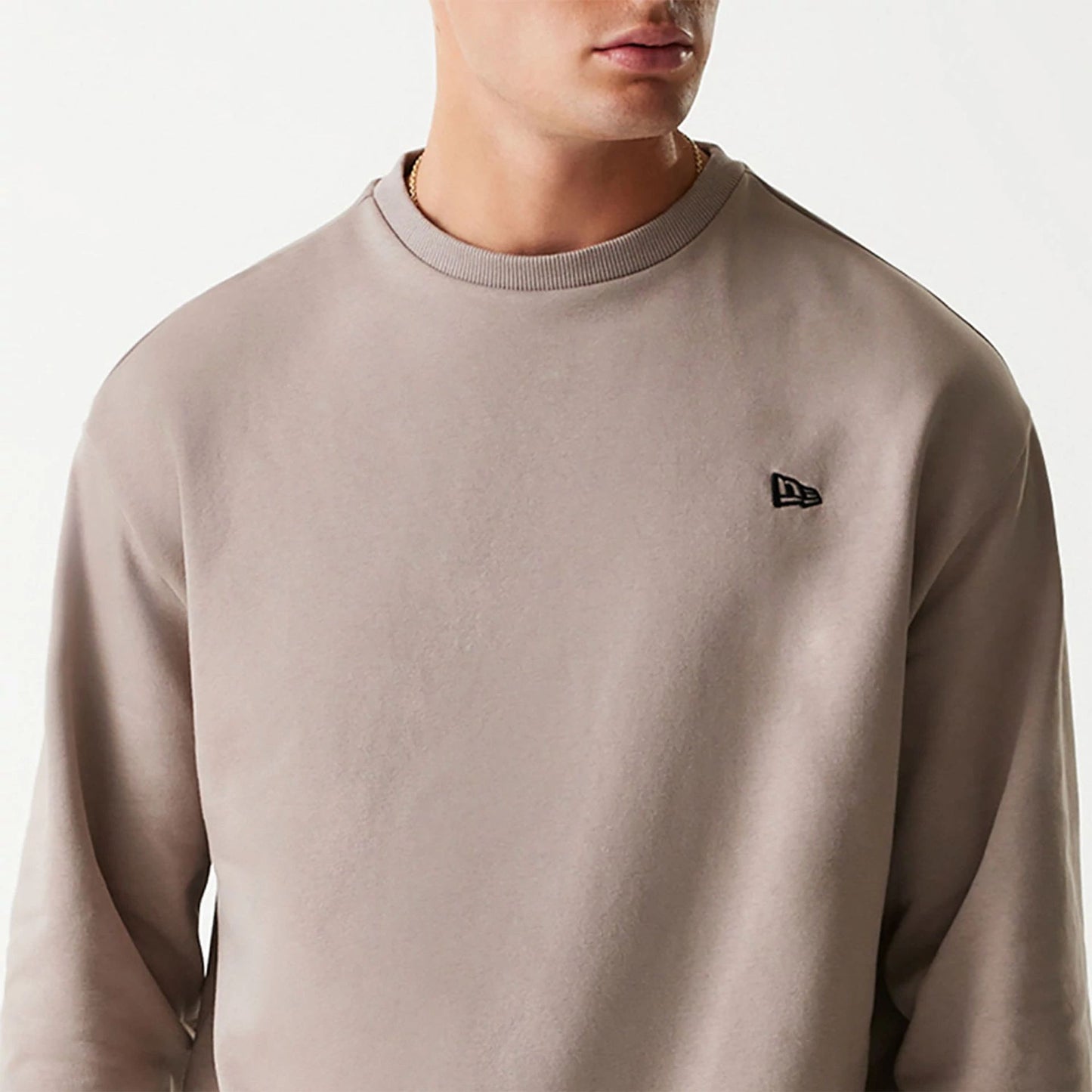 The Male model is wearing New Era Essential Brushed Fleece Pastel Brown Crewneck Sweater 3