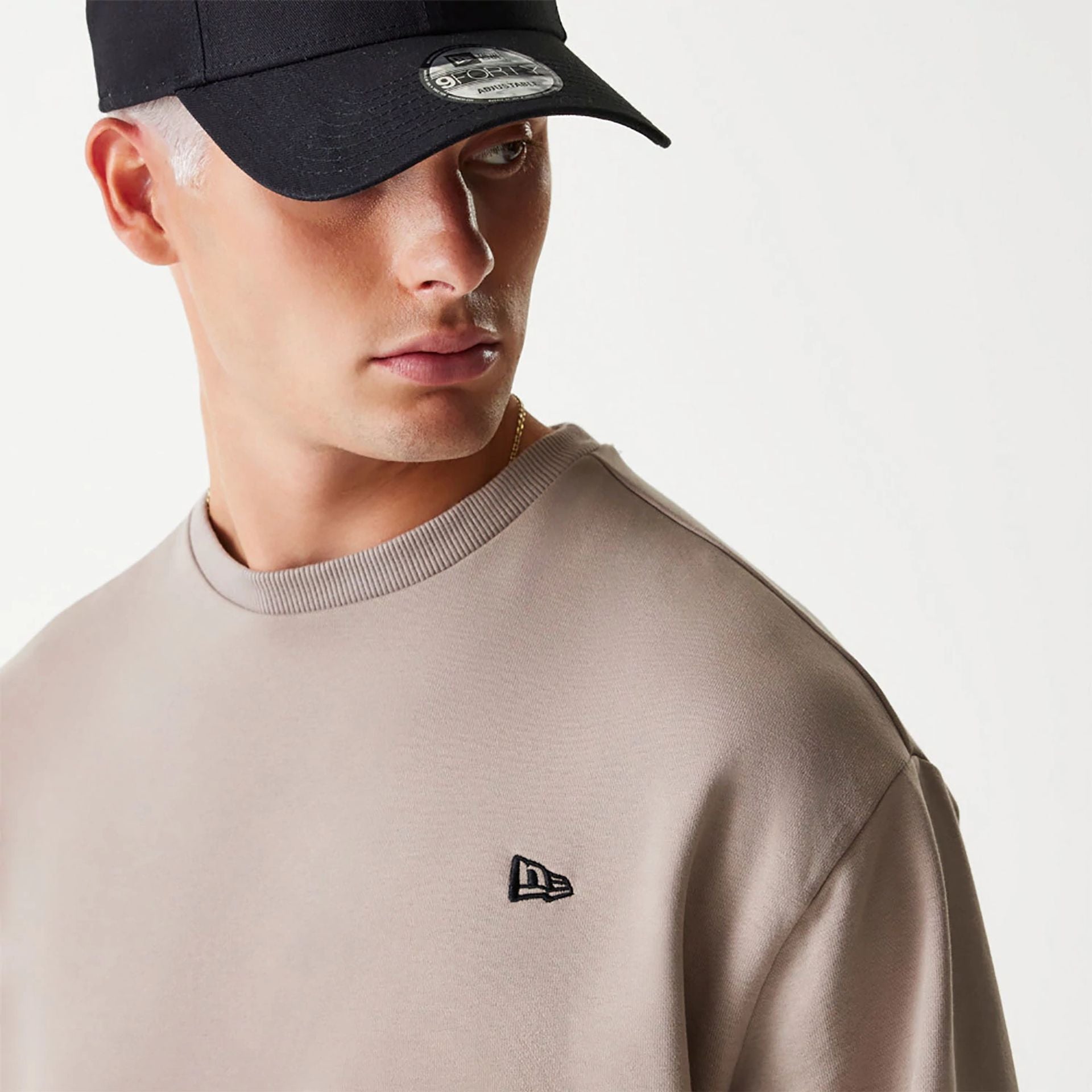 The Male model is wearing New Era Essential Brushed Fleece Pastel Brown Crewneck Sweater 5