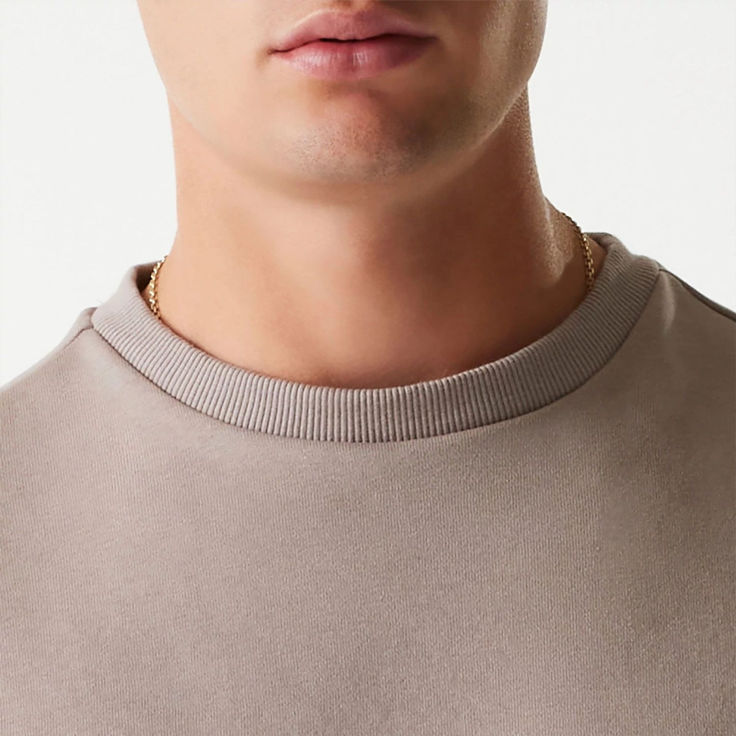 The Male model is wearing New Era Essential Brushed Fleece Pastel Brown Crewneck Sweater 6