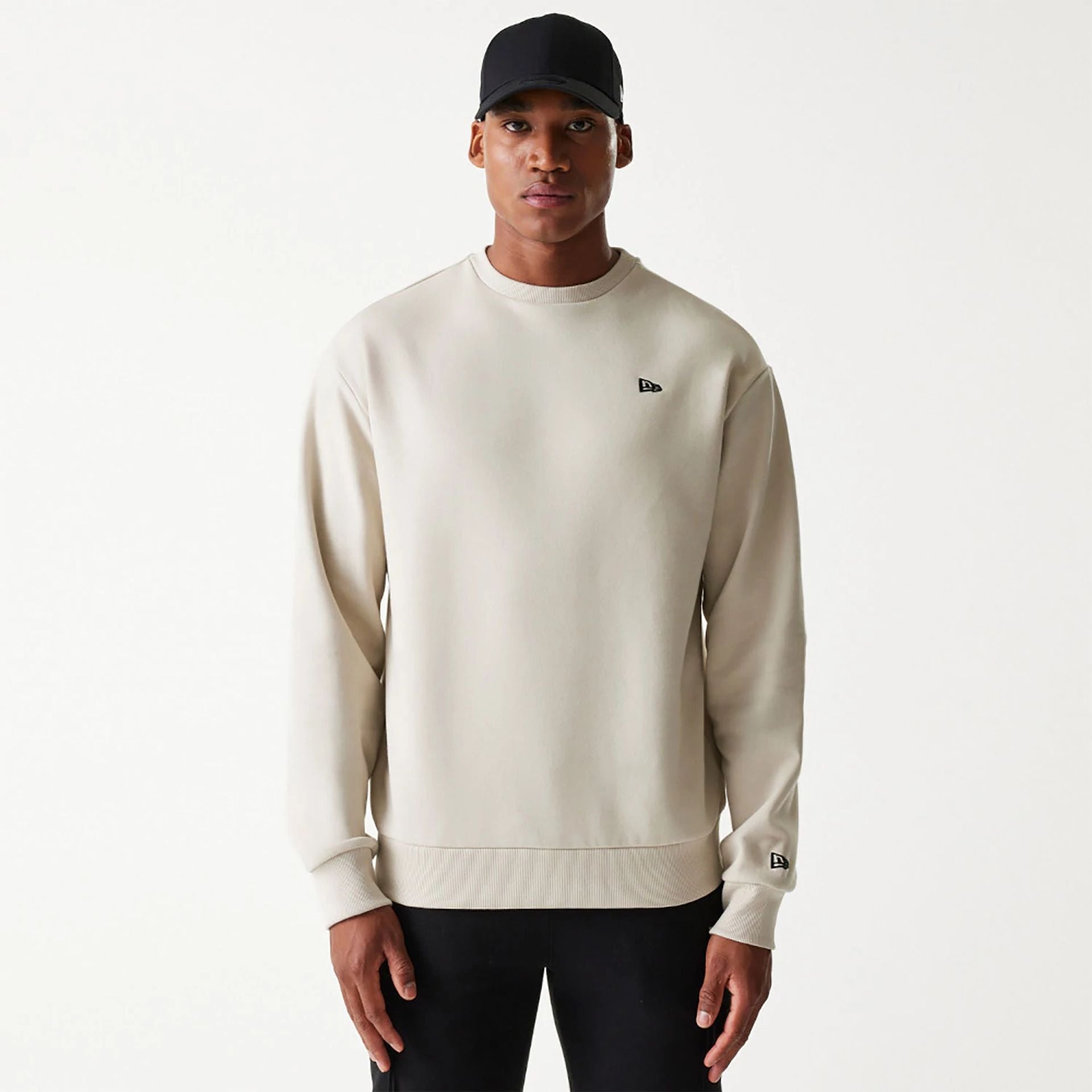 The Male model is wearing New Era Essential Brushed Fleece Light Beige Crewneck Sweater 1