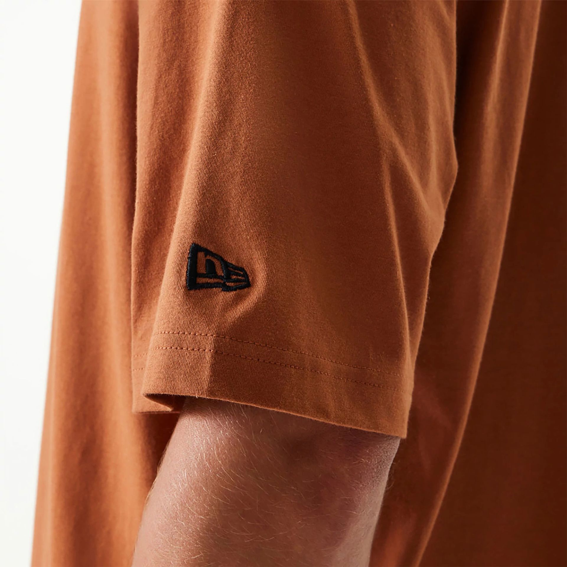 The Male model is wearing New Era Essential Brown Oversized T-Shirt 4