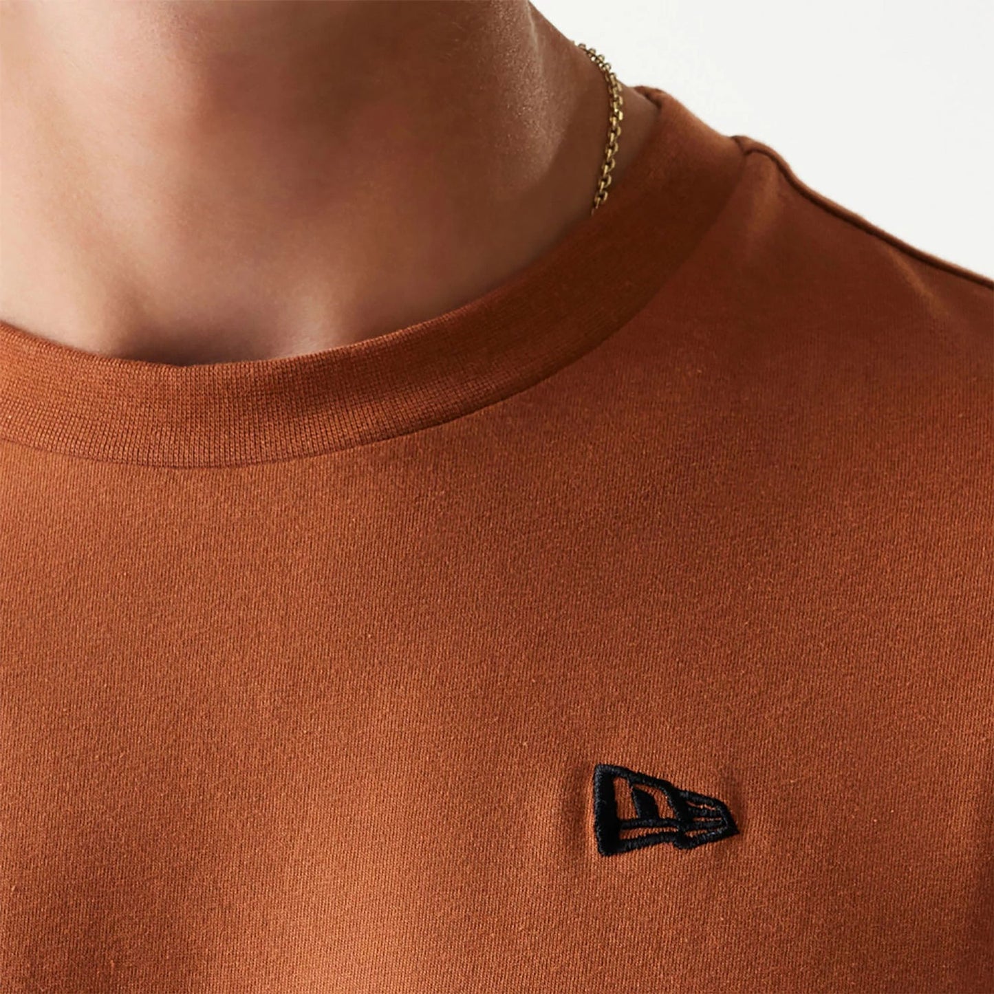 The Male model is wearing New Era Essential Brown Oversized T-Shirt 5