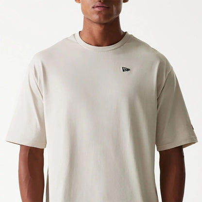 The Male model is wearing New Era Essential Light Beige Oversized T-Shirt 3