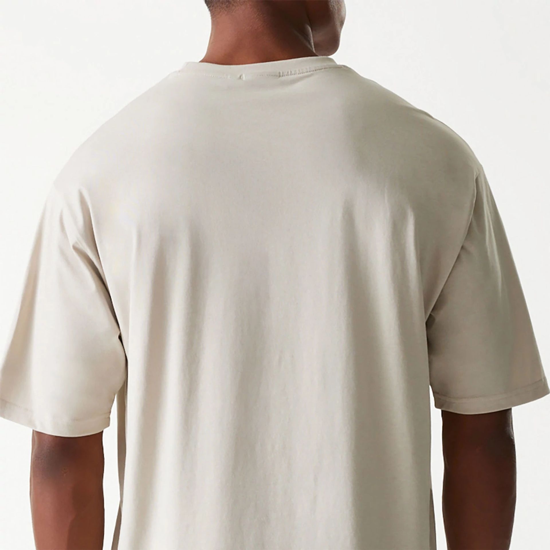 The Male model is wearing New Era Essential Light Beige Oversized T-Shirt 7