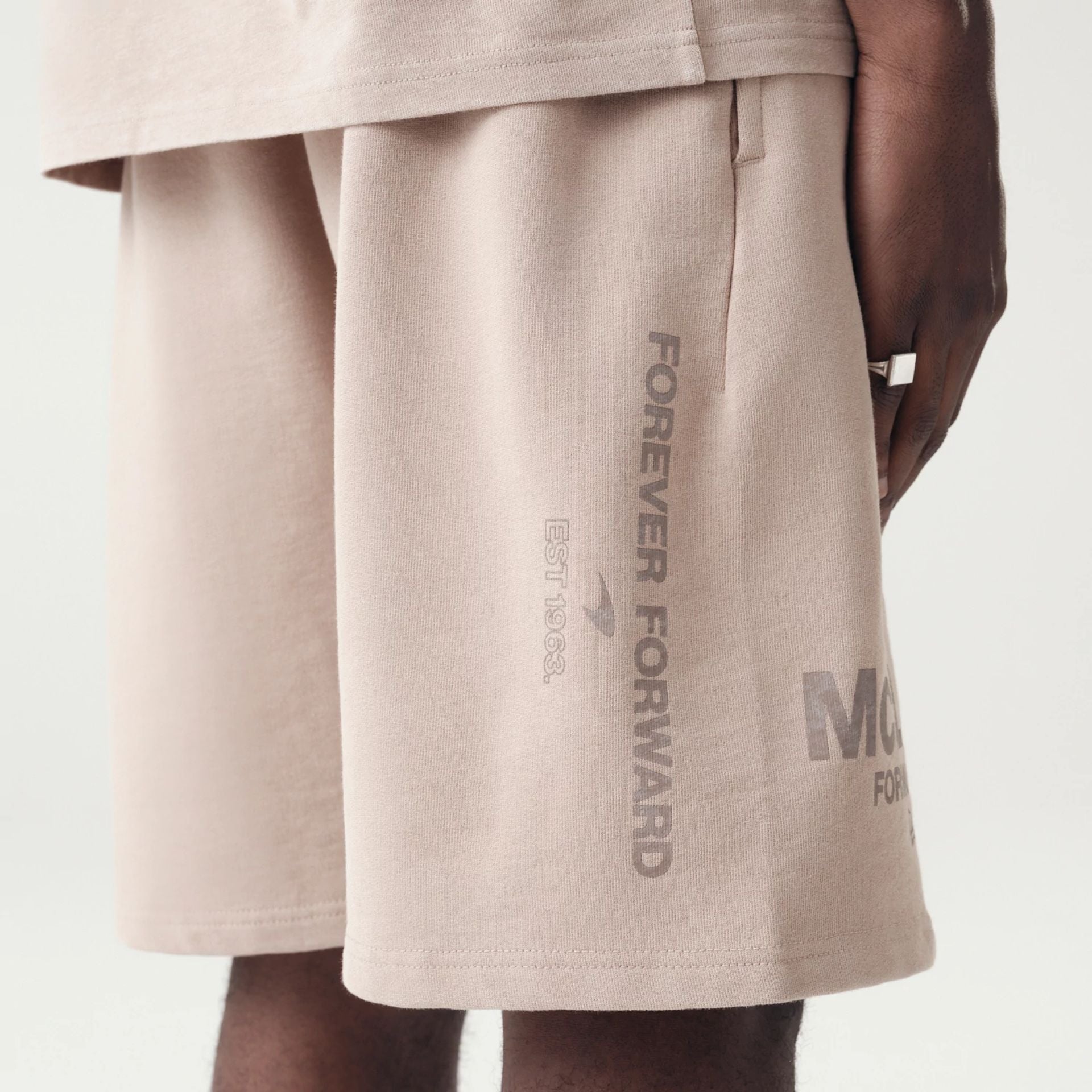 The Male model is wearing McLaren Racing Washed Pack Beige Oversized Shorts 4