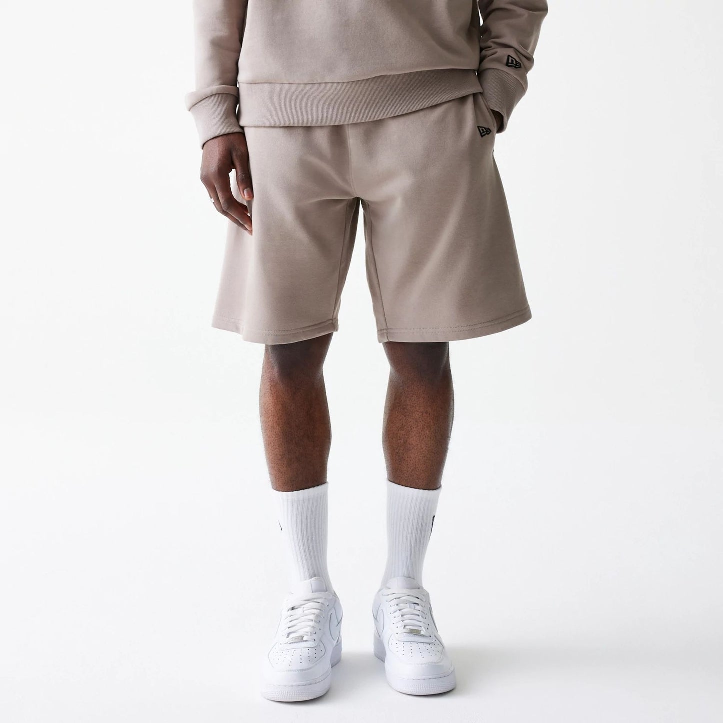 The Male model is wearing New Era Pastel Brown Oversized One Panel Shorts 6