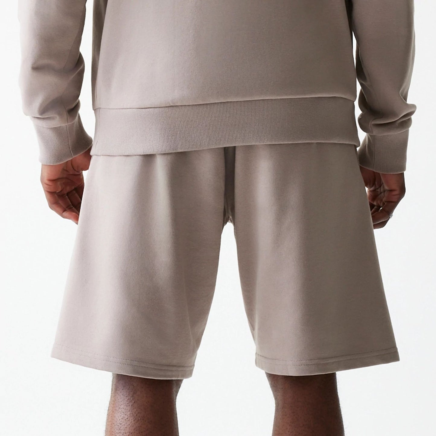 The Male model is wearing New Era Pastel Brown Oversized One Panel Shorts 7