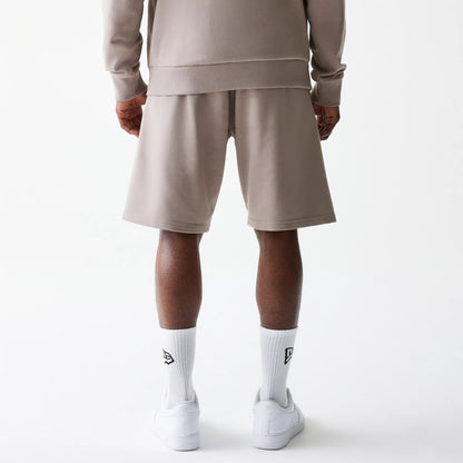 The Male model is wearing New Era Pastel Brown Oversized One Panel Shorts 2