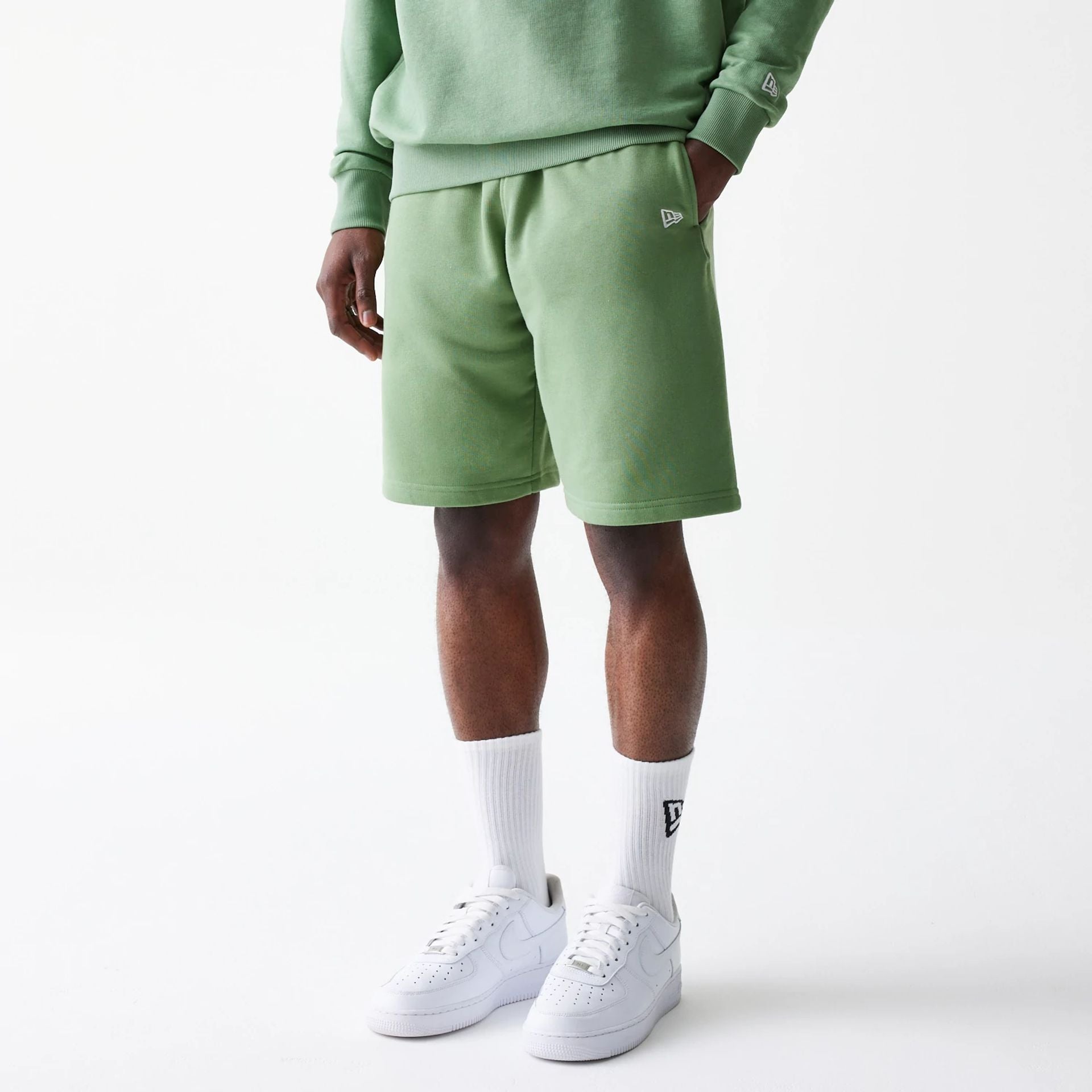 The Male model is wearing New Era Green Oversized One Panel Shorts 1