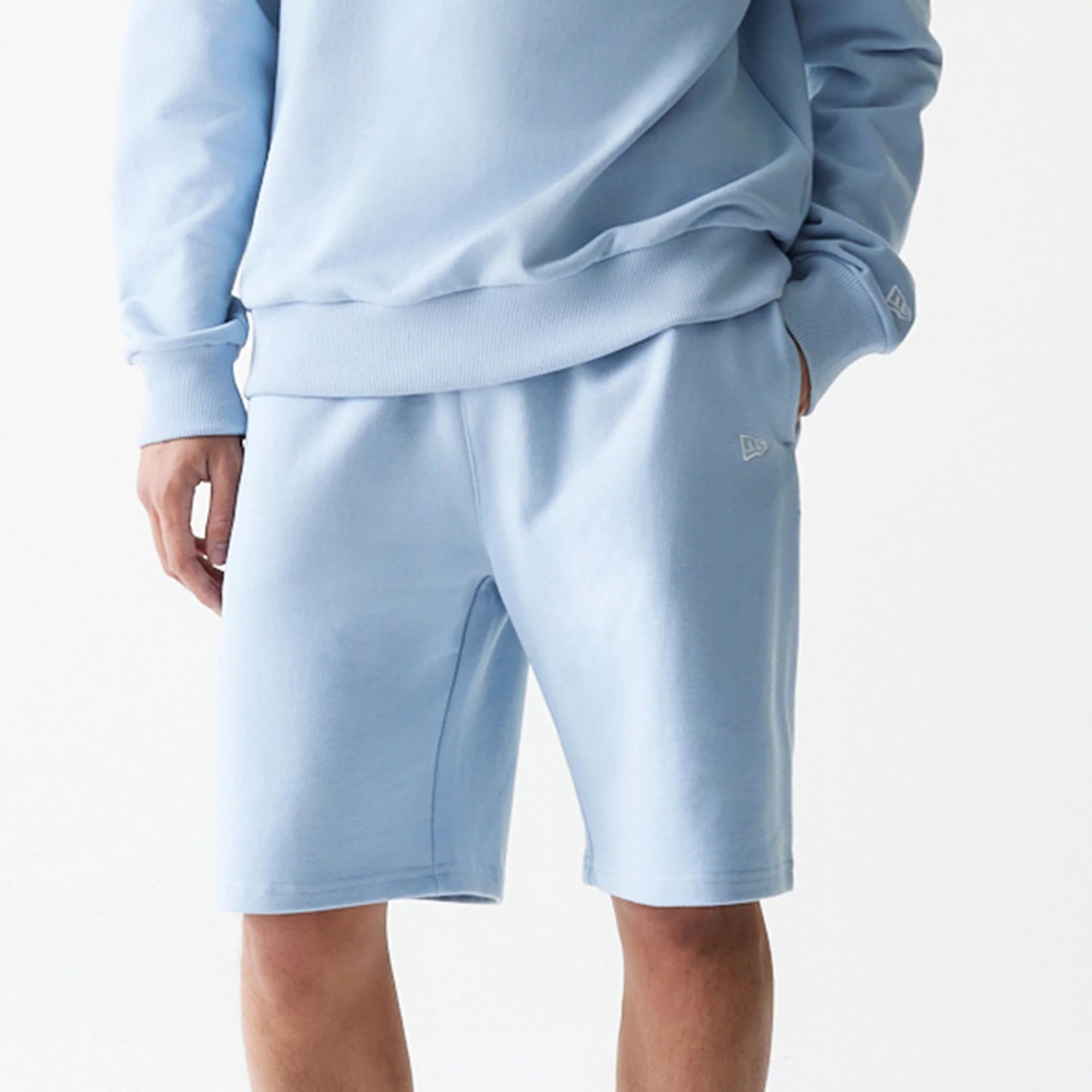 The Male model is wearing New Era Pastel Blue Oversized One Panel Shorts 3