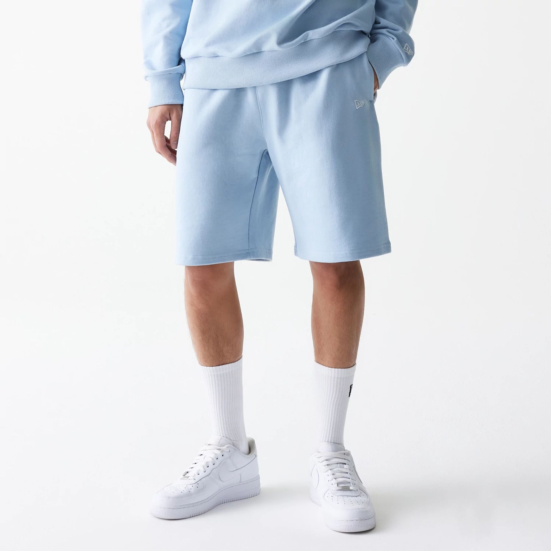 The Male model is wearing New Era Pastel Blue Oversized One Panel Shorts 1