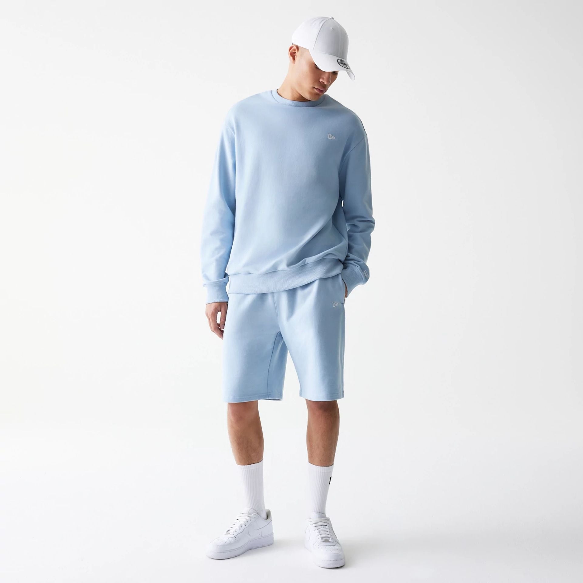 The Male model is wearing New Era Pastel Blue Oversized One Panel Shorts 8