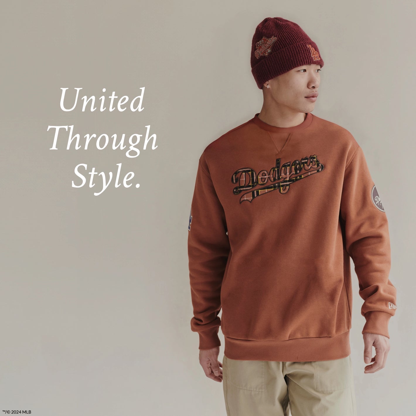 A model wearing red LA Dodgers beanie, orange dodgers sweatshirts with beige pants. 